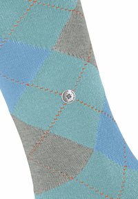 Calzino colorato con un motivo a rombi in tonalità di blu e grigio, con cuciture arancioni e un accento di logo argentato.