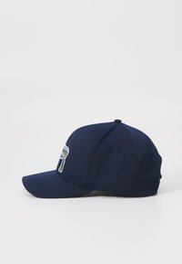 Navy blue cap made of cotton with a curved visor. Features an embroidered design on the front panel and ventilation eyelets.