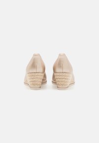 Nude wedge sandale s glatkom kožnom gornjom stranom i pletenim jute potplatom, visine približno 7 cm, s čvrstim gumiranim đonom.