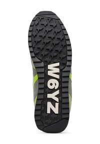 Suola di scarpa in gomma nera con un motivo testurizzato a stella, caratterizzata da una tomaia grigia e dettagli in verde brillante, con il testo "W6YZ" in bianco.