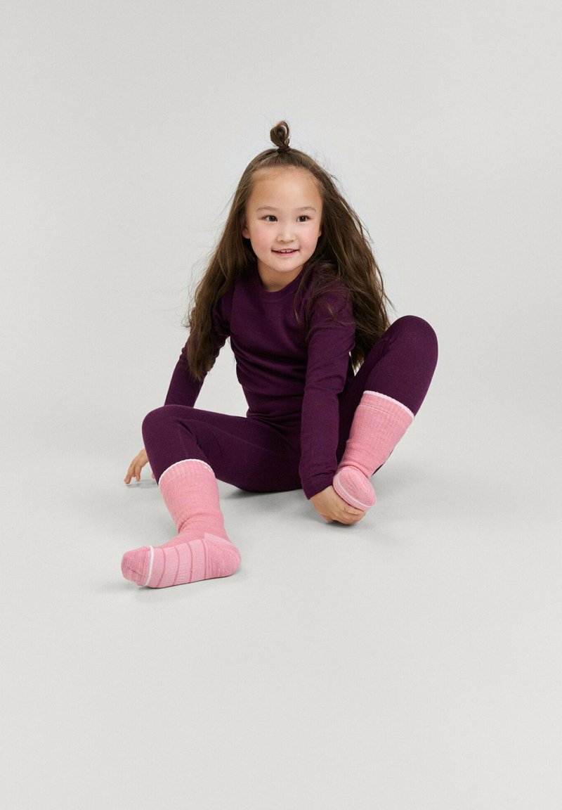Maglietta a maniche lunghe viola e leggins con calzini a righe rosa. L'outfit presenta una vestibilità aderente e una texture morbida, ideale per il comfort.