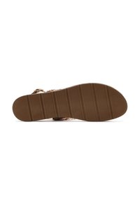 Brown rubber sole with vertical grooves, featuring a patterned strap made of woven material. Smooth, rounded toe design.