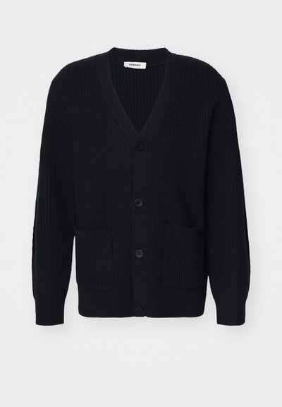 Tumed sinine kudum cardigan, millel on V-kaelus, viis nööpi, soonikuline tekstuur ja kaks esikotti.