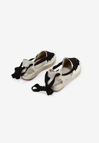 Espadrillas in tessuto nero con suole in juta intrecciate, dotate di un design slip-on e nastri sul retro. Fodera interna liscia.
