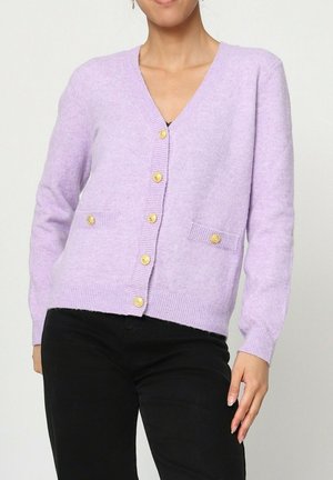 Cardigan lilas en tissu tricoté, avec un col en V, des poignets côtelés et deux poches avec des boutons dorés à l'avant.