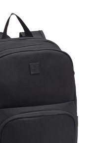 Zaino nero realizzato in tessuto resistente, con una forma rettangolare, diversi scomparti con zip e un logo ben visibile sulla parte frontale.