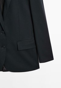 Černé sako z hladké látky má zapínání na jeden knoflík, klopový límec s výřezem, náprsní kapsu a strukturovaná ramena.