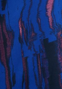 Tissu bleu avec des stries verticales irrégulières en violet foncé et rouge, créant un motif texturé abstrait.