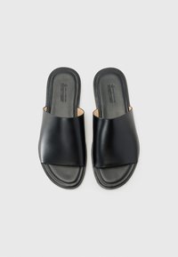 Black slide sandals featuring a smooth leather upper with a wide strap design and soft footbed, set against a plain background.