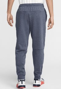 Joggers atléticos de color azul marino fabricados en un tejido suave, con cintura elástica, piernas ajustadas y bolsillos laterales.