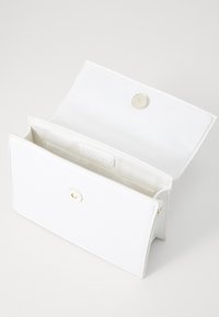 Biała skórzana portmonetka o gładkiej fakturze, złote zapięcie na zatrzask i dwie wewnętrzne przegrody. Prosty design, kształt prostokątny.