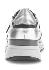 Zilveren metallic sneaker met een gepolsterde hiel, contrasterende zwarte accenten, textuurmateriaal en een stevige rubberen zool. Het achteraanzicht toont de ontwerpdetails.