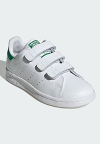 Balti ādas skrējēji ar trim regulējamām Velcro siksnām, zaļa akcenta detaļa uz papēža, perforēts dizains ventilācijai un gumijas zole.