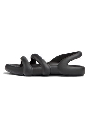 Zwarte sandalen met een uniek, sculpturaal ontwerp. Gemaakt van flexibel materiaal, met gebogen bandjes en een open achterkant voor ventilatie.