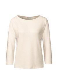 Maglietta lunga beige chiaro a maniche lunghe realizzata in tessuto a costine, con scollatura rotonda e orlo dritto. Design semplice senza decorazioni.