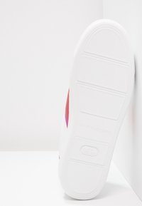 Sneaker blanche avec une semelle texturée, dotée d'une tige en maille rose et rouge. Conçu avec un profil épuré et des éléments de marque minimalistes.