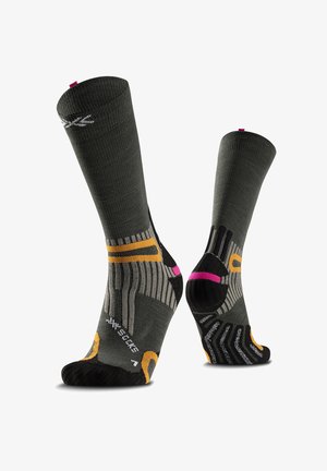 Chaussettes de sport gris foncé avec des accents orange, rose et noir, texture côtelée, et zones renforcées aux orteils et au talon, présentées de profil et de dos.