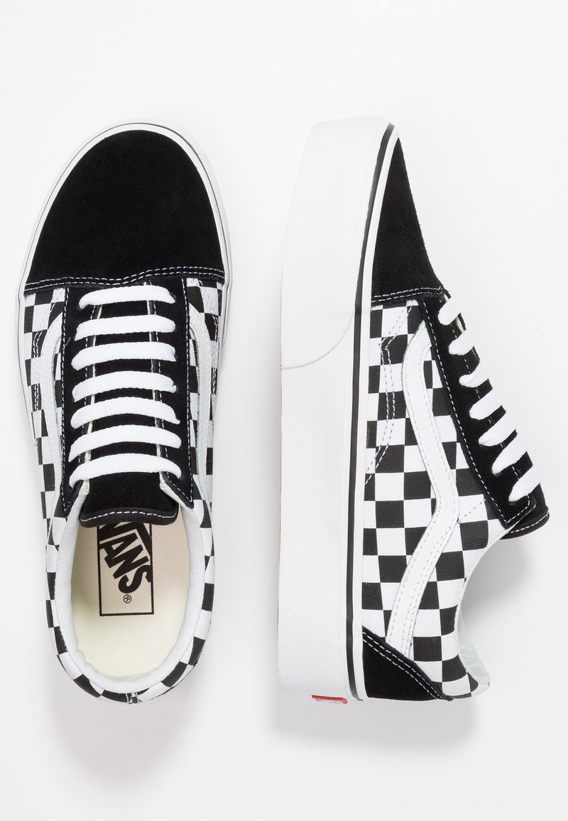 Zapatillas de lona en blanco y negro con un diseño de tablero de ajedrez y detalles en ante, suelas de goma blanca y cordones planos clásicos. Marca Vans en el interior.