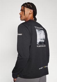 Adidas Terrex NATIONAL GEOGRAPHIC UNITEFIT GFX TEE LS - Tops ar garām piedurknēm - black
