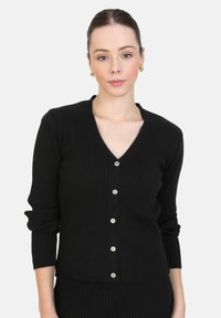 Cardigan noir à côtes avec un décolleté en V, des manches longues et cinq boutons argentés sur le devant. Texture douce et design ajusté.