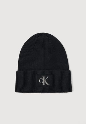 Must värvitud kootud beanie ribakujulise tekstuuriga ja volditud äärega. Ees on ristkülikukujuline silt, millel on metallik hõbedane "CK" logo.