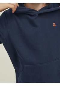 Námořnická modrá mikina s kapucí vyrobená z měkké bavlněné směsi, s přední kapsou a oranžovým vyšitým logem "&" na hrudi.