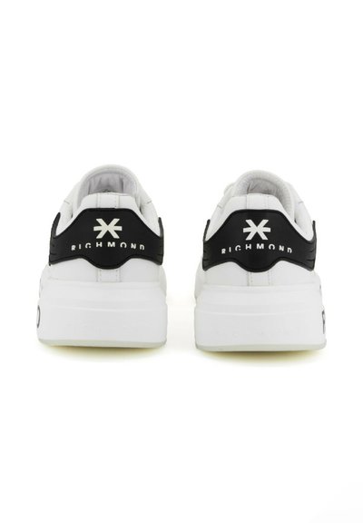 Le sneakers in bianco e nero presentano una suola chunky, materiali in pelle e tessuto, un marchio in rilievo sul tallone e una finitura liscia.