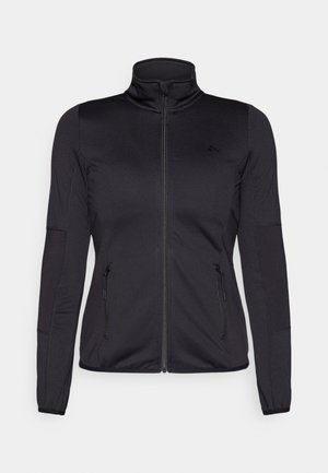 Chaqueta negra con cremallera y cuello alto, confeccionada en un tejido liso y elástico, que cuenta con dos bolsillos delanteros con cremallera y mangas con textura.