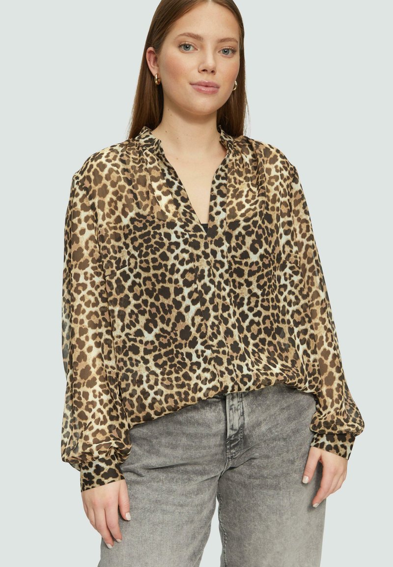 Bluse mit Leopardenmuster, langen Ärmeln, V-Ausschnitt und gerafften Schultern. Hergestellt aus leichtem Stoff in Brauntönen und Creme.