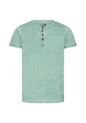 T-shirt en coton vert menthe avec un col rond, des manches courtes et une patte de boutonnage à quatre boutons marron. Tissu doux et texturé avec une finition délavée.
