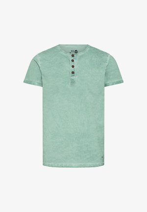 T-shirt en coton vert menthe avec un col rond, des manches courtes et une patte de boutonnage à quatre boutons marron. Tissu doux et texturé avec une finition délavée.