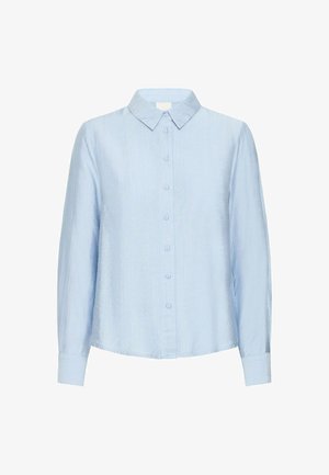 Chemise bleu clair à manches longues avec un tissu texturé, un col pointu et des poignets, présentant une coupe droite et des détails minimaux.