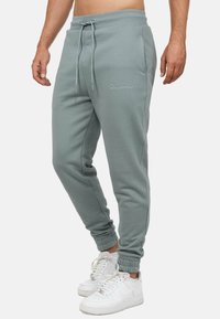 Lichtgrijze joggingbroek van katoenmix met elastische boorden en een verstelbare trekkoord in de taille. Voorzien van een subtiele geborduurde logo op de linkerdij.
