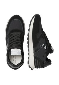 Un paio di scarpe da ginnastica atletiche bianche e nere con suole testurizzate, tomaia in mesh e camoscio, e etichetta con marchio sulla linguetta su sfondo bianco.
