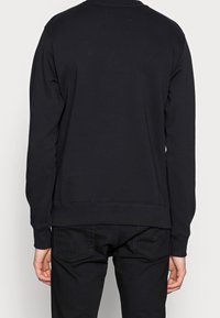 Svart sweatshirt med långa ärmar och ribbad krage. Har en enfärgad design, tillverkad av bomullsblandat tyg, med en avslappnad passform.