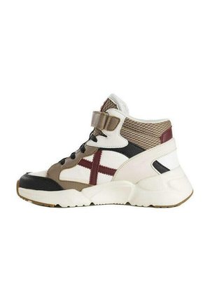 Zapatilla alta que presenta una mezcla de materiales en beige, blanco y negro con acentos de malla, un destacado logo rojo y una suela blanca gruesa.