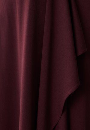 Burgundi värvi kangas, millel on sujuv ja matte tekstuur, mis on elegantselt riputatud, et näidata pehmeid voldikuid ja õrnu kontuure. Ei mingeid nähtavaid mustreid ega metallosi.