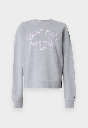 Siva skrajšana majica s dolgimi rokavi, z vijoličnim izvezenim napisom "TOMMY JEANS NEW YORK CITY" po prsih in rebrastimi manšetami.
