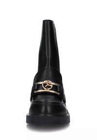 Stivaletti neri in pelle con punta affusolata, dotati di una cinturino con accenti dorati e hardware sul puntale, upper testurizzato e suola piatta.