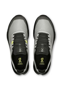 Graue wasserdichte Sneakers mit einer strukturierten Oberseite, schwarzen Akzenten, gelben Details und einem schwarzen Innenfutter, das für Komfort und Unterstützung sorgt.