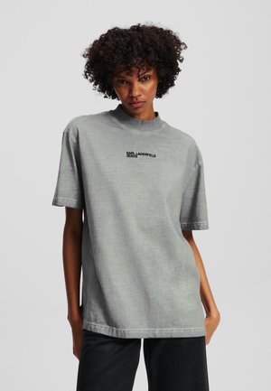 Oversized grey cotton t-shirt with a high neckline, short sleeves, and embroidered "KARL LAGERFELD JEANS" text on the front.