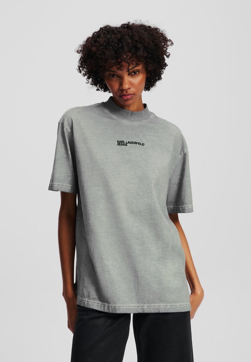 Overdimensjonert grå bomull T-skjorte med høy hals, korte ermer, og brodert "KARL LAGERFELD JEANS" tekst på fronten.