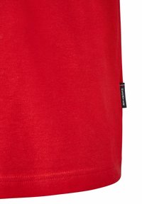 Rode katoenen t-shirt met een soepele textuur en een klein zwart-wit label aan de zoom. Het design heeft een eenvoudige snit.