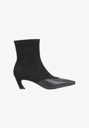 Black ankle boot made of suede with a smooth leather toe. Features a pointed shape and a mid-height heel. Simple, sleek design.