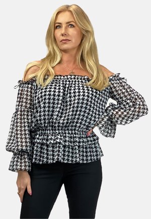 Bluzka w czarno-białą kratkę houndstooth, odkrywająca ramiona, z falbaniastymi rękawami i dopasowaną talią. Wykonana z lekkiego, przezroczystego materiału.