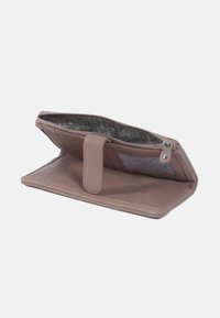 Roze leren portefeuille met een ritssluiting, interieur met een patroonvoering, een klep met knoop en een doorzichtige kaartenslot. Open bij een brede compartiment.