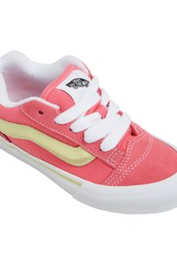 Baskets en toile rose corail avec lacets blancs et semelle en caoutchouc ; dotées d'une bande d'accent jaune et du logo Vans sur la languette.