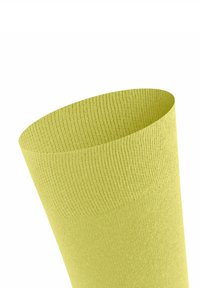 Grüner, strukturierter Socken mit einem gerippten Muster, das sich zur Öffnung hin verjüngt. Das Material wirkt weich und dehnbar mit einem nahtlosen Design.