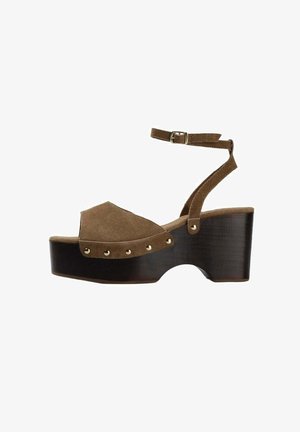 Bruine suède plateau sandaal met enkelriem en gouden studs, met een stevige hoge houten hak en open teen ontwerp.