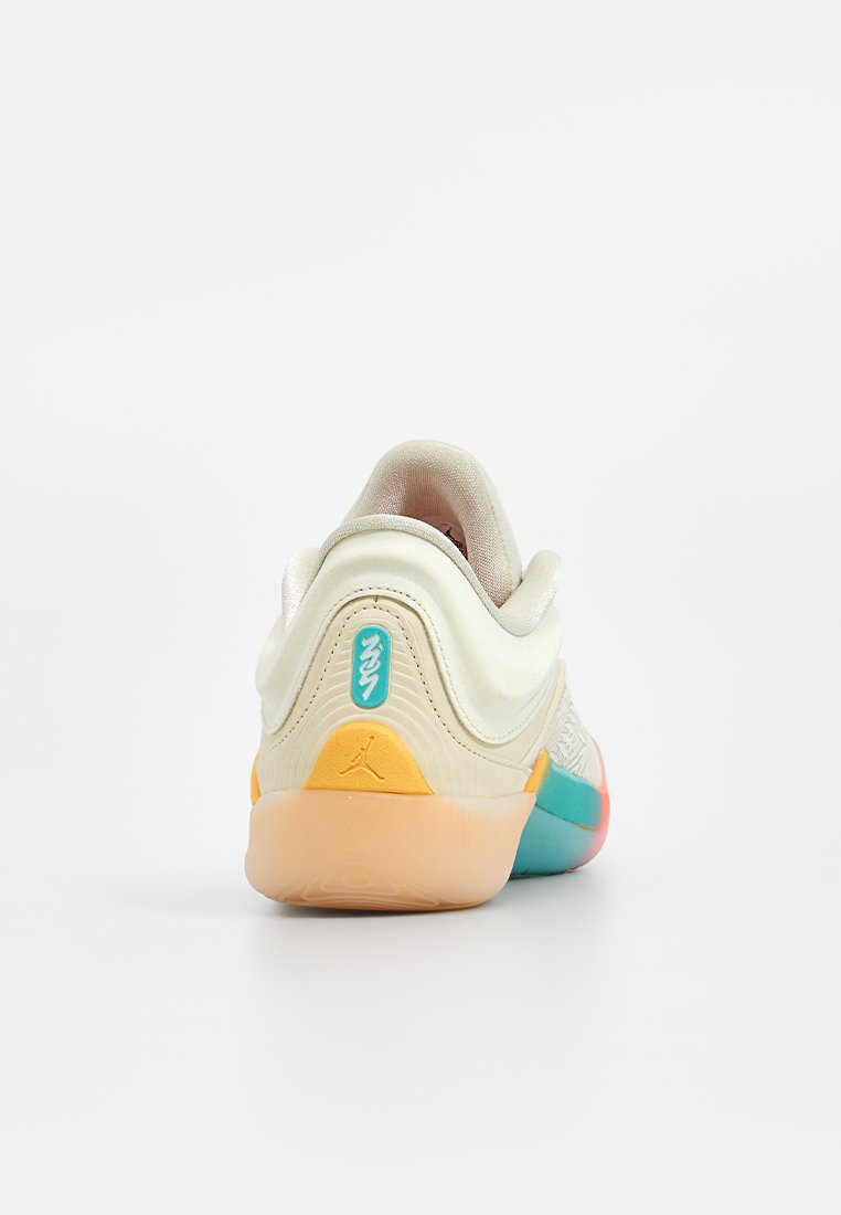 Zapatilla con un upper suave en color crema, diseño texturizado y suela multicolor en naranja, azul verdoso y rosa. Incluye un detalle de marca en el talón.